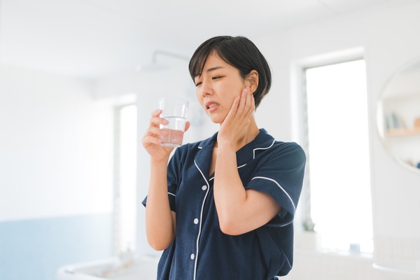 冷たい水で歯がしみている女性|知覚過敏と虫歯の違いとは?症状・原因・治療法をわかりやすく解説|金属アレルギー・掌蹠膿疱症専門歯科医療サイト|愛媛県松山市もりもと歯科クリニック